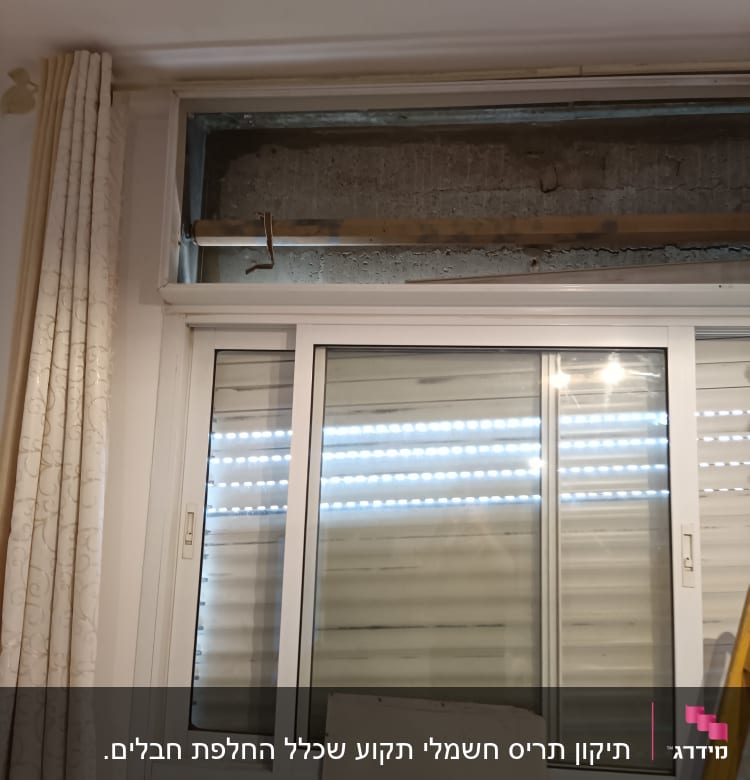 Window with partially open shutters and visible curtain rod.